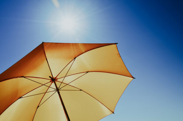 Sonnenschirm unter blauem Himmel und Sonne